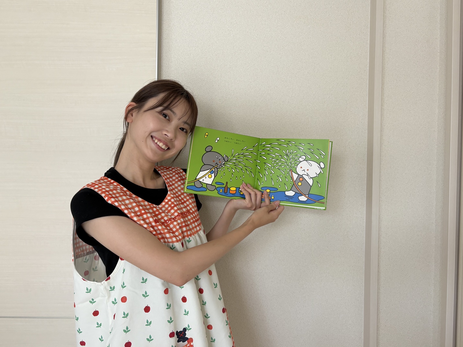 いとのわ代表の髙橋日向子が、絵本を手に笑顔を見せている様子